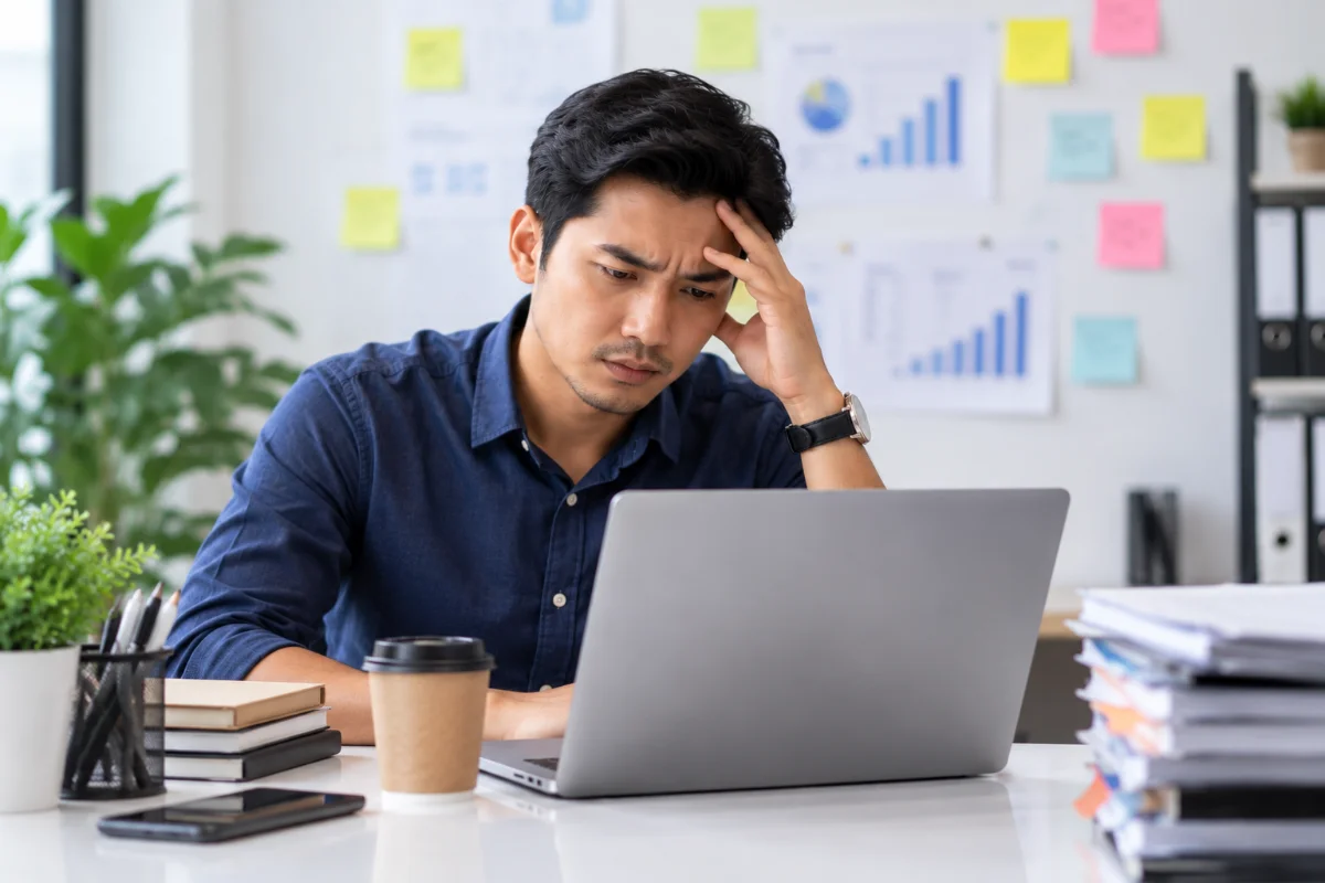 Lelaki penat bekerja di hadapan laptop